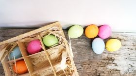 Керамични цветни яйчица висящи в дървена щайга