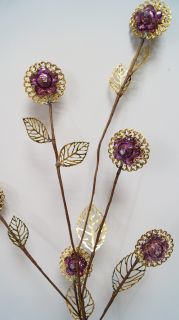 Златен клон с лилави топчета за декорация            